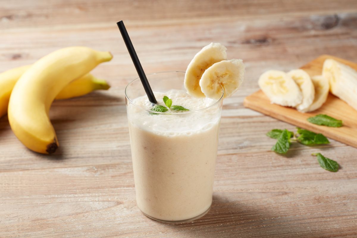 frullato alla banana con cucchiaio in primo piano: cibo fresco, morbido e privo di croccantezza, ideale nelle prime fasi dopo l’inserimento di un impianto dentale.
